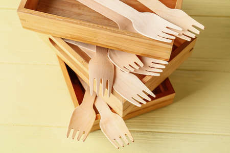 Wooden forks and boxes on color backgroundの写真素材