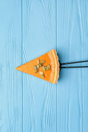 Spatula with slice of tasty pumpkin pie on color wooden backgroundの写真素材