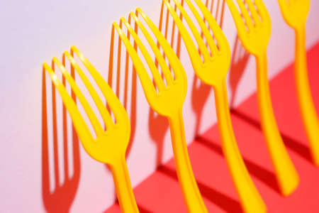 Plastic forks on color background