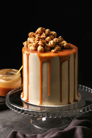 Tasty cake with popcorn and caramel on dark backgroundの写真素材