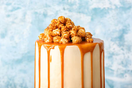 Tasty cake with popcorn and caramel on color background, closeupの写真素材