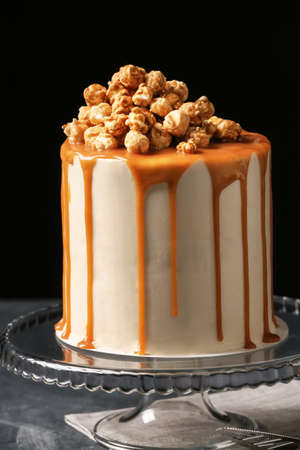 Tasty cake with popcorn and caramel on dark backgroundの写真素材