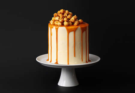 Tasty cake with popcorn and caramel on dark backgroundの写真素材