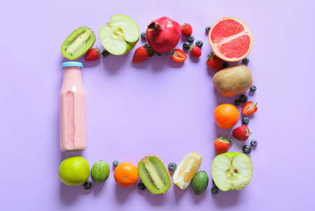 Frame made of bottle with tasty smoothie and fruits on color backgroundの写真素材