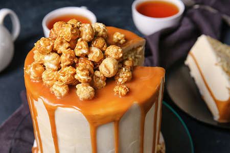 Tasty cake with popcorn and caramel on dark background, closeupの写真素材