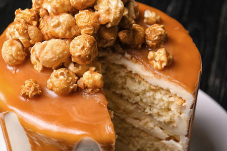 Tasty cake with popcorn and caramel on dark background, closeupの写真素材