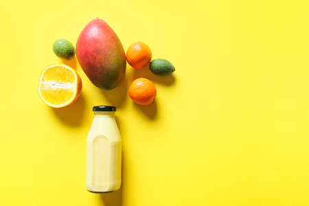 Bottle of tasty smoothie with fruits on color backgroundの写真素材