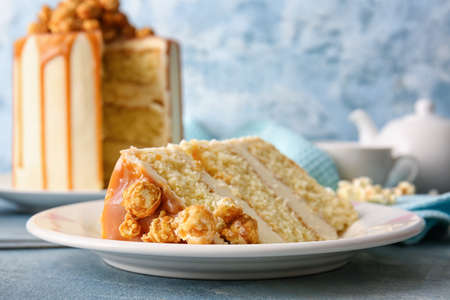 Plate with piece of tasty cake on color background, closeupの写真素材