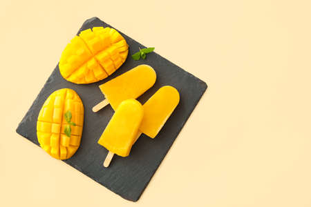 Board with mango ice cream on light backgroundの写真素材