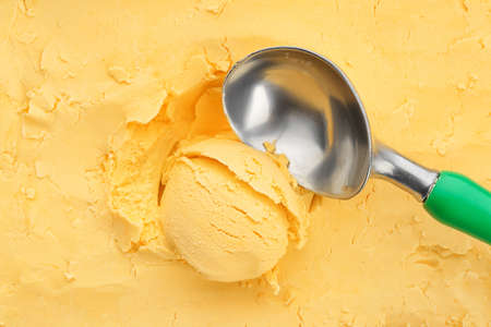 Scoop with tasty mango ice cream, closeupの写真素材