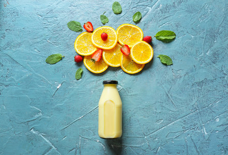 Bottle of tasty smoothie with fruits on color backgroundの写真素材