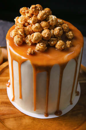 Tasty cake with popcorn and caramel on dark background, closeupの写真素材