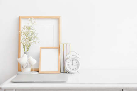 Stylish workplace with laptop against light wall in room