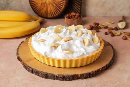 Board with tasty banana pie on color backgroundの写真素材