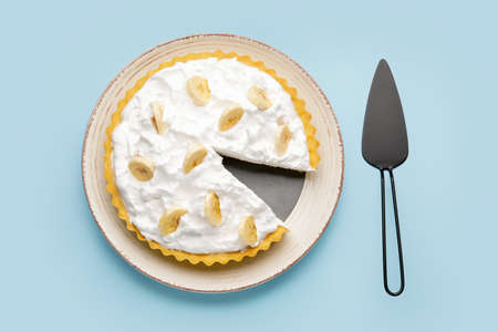 Plate with tasty banana pie and spatula on color backgroundの写真素材