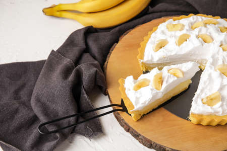 Board with tasty banana pie on tableの写真素材