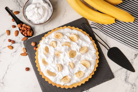 Board with tasty banana pie on tableの写真素材