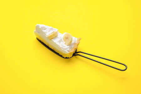 Spatula with piece of tasty banana pie on color backgroundの写真素材