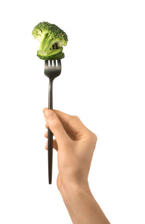 Female hand and fork with broccoli and cucumber on white backgroundの写真素材