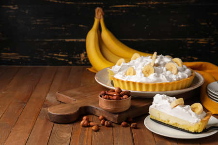 Plate with piece of tasty banana pie on wooden tableの写真素材