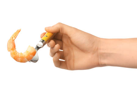 Female hand and fork with shrimp on white backgroundの写真素材