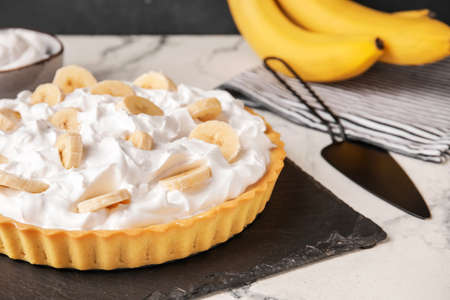 Board with tasty banana pie on tableの写真素材