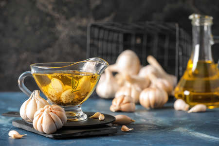 Gravy boat with garlic oil on color backgroundの写真素材