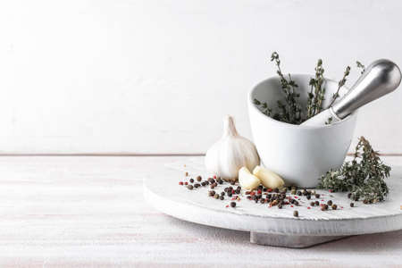 Mortar with spices and pestle on light backgroundの写真素材