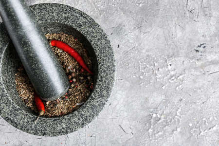 Mortar with spices and pestle on gray backgroundの写真素材