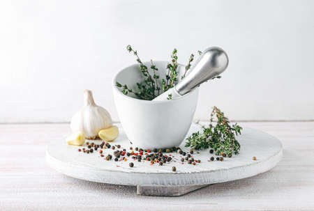 Mortar with spices and pestle on light backgroundの写真素材
