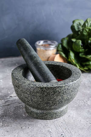 Mortar with spices and pestle on gray backgroundの写真素材