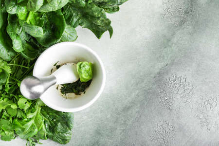 Mortar with herbs and pestle on tableの写真素材