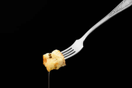 Fork with piece of bread and sauce on dark backgroundの写真素材