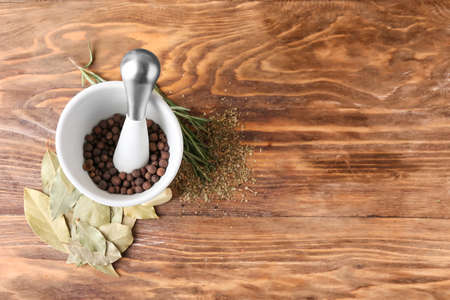 Mortar with spices and pestle on wooden backgroundの写真素材