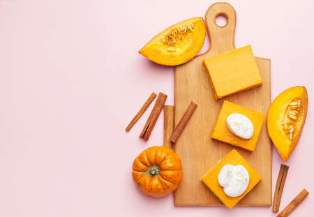Board with pieces of tasty pumpkin pie on color backgroundの写真素材