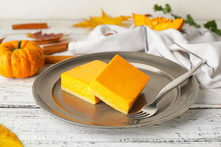 Plate with pieces of tasty pumpkin pie on tableの写真素材