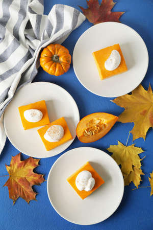Plates with pieces of tasty pumpkin pie on color backgroundの写真素材