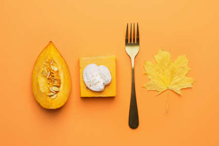 Piece of tasty pumpkin pie and fork on color backgroundの写真素材
