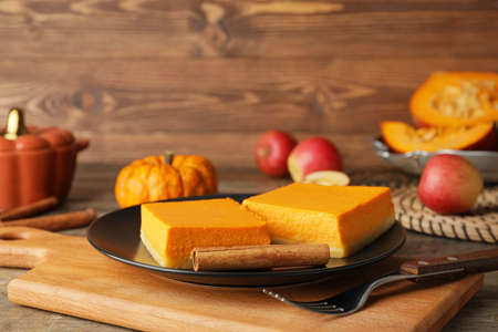 Plate with pieces of tasty pumpkin pie on tableの写真素材