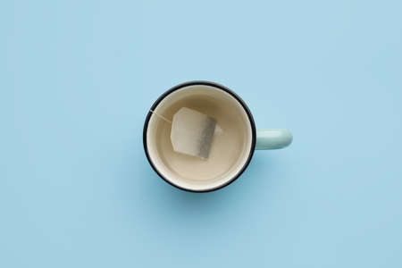 Cup with tea bag on color backgroundの写真素材
