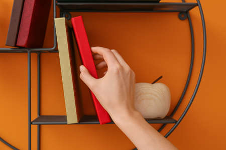 Woman taking book from shelf, closeupの写真素材