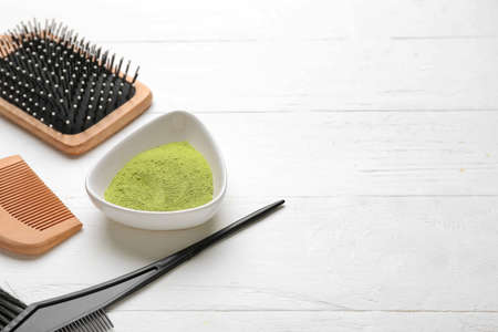 Bowl with henna and hair combs on white wooden backgroundの写真素材