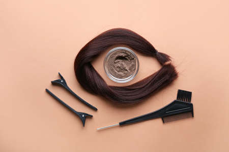 Bowl with henna, hair and hairdresser's supplies on color backgroundの写真素材