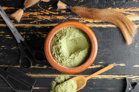 Bowl with henna, hair and hairdresser's supplies on dark wooden background, closeupの写真素材