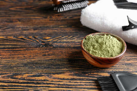 Bowl with henna and hairdresser's supplies on dark wooden backgroundの写真素材