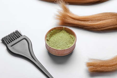 Bowl with henna, hair and brush on white backgroundの写真素材