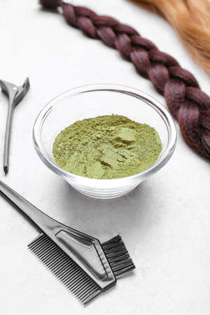 Bowls with henna, hair and hairdresser's supplies on white backgroundの写真素材