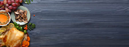 Tasty baked turkey and different food for Thanksgiving Day on wooden background with space for textの写真素材