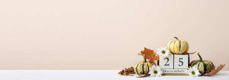 Autumn composition with pumpkins and calendar with date of Thanksgiving Day on light background with space for textの写真素材