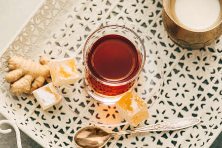 Glass of tasty Turkish tea and delights on light backgroundの写真素材